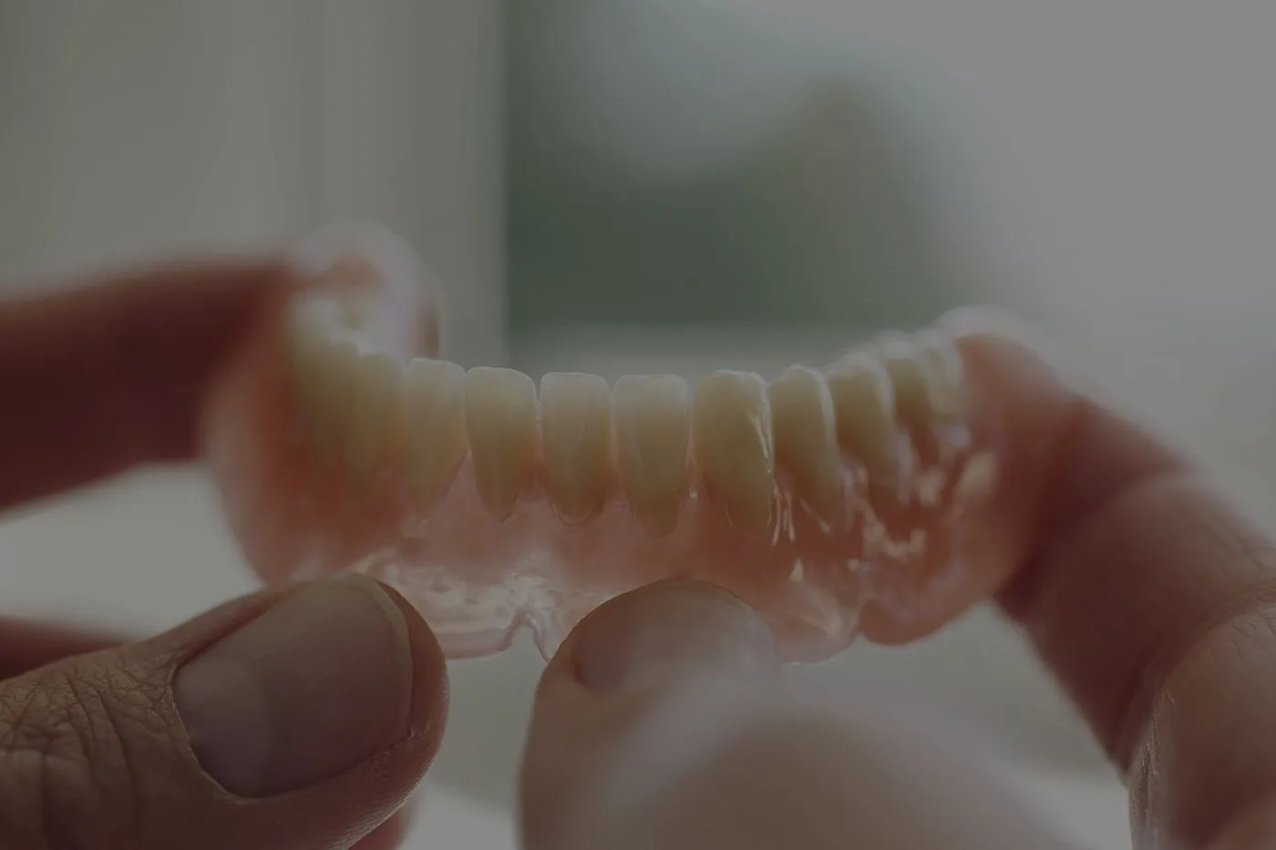 Close-up of a dental prosthetist holding a finished denture