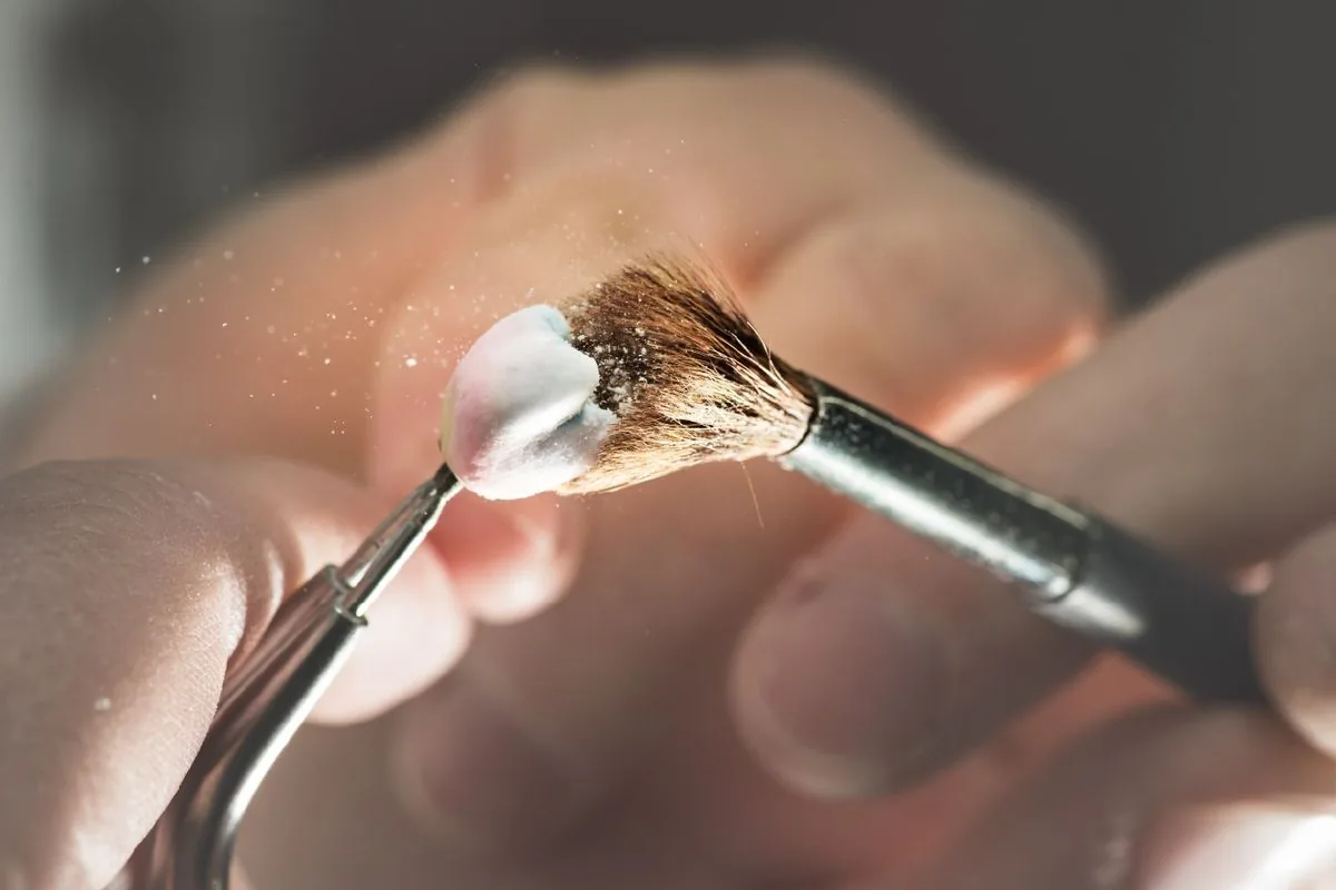 Dental technician finishing a denture with a fine brush in the laboratory